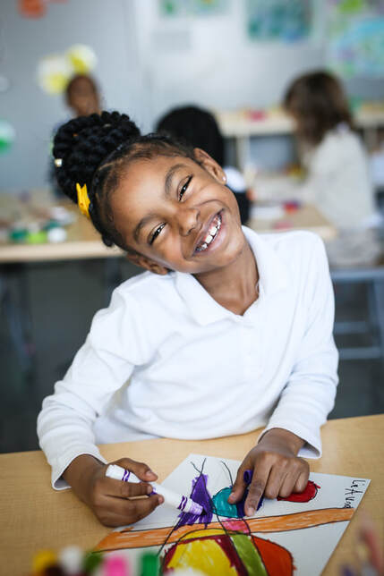 Smiling student coloring with marker